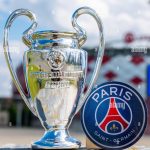 june-14-2021-paris-france-the-emblem-of-the-football-club-paris-saint-germain-fc-and-the-uefa-champions-league-cup-against-the-backdrop-of-a-mode-2GJ2F2P-3556280523